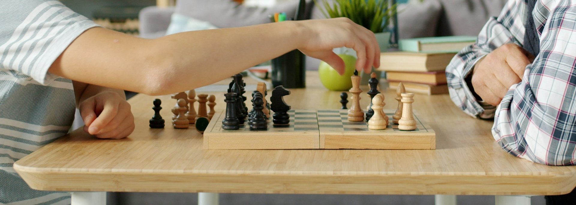 Kinderhand zieht eine Figur, ein Großvater schaut zu